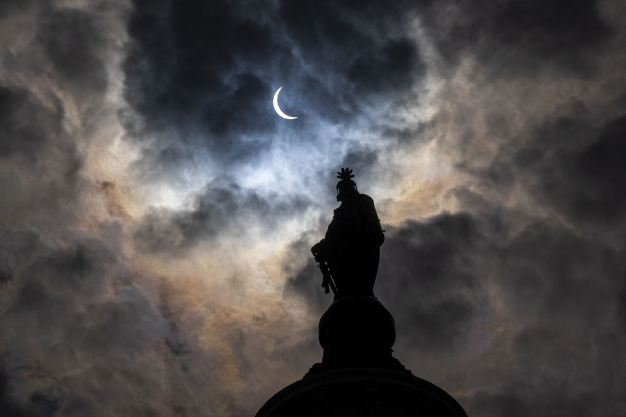 The Statue of Freedom on top of the U.S. Capitol stands as the moon partially covers the sun during a total solar eclipse, as seen from Capitol Hill, Monday, April 8, 2024, in