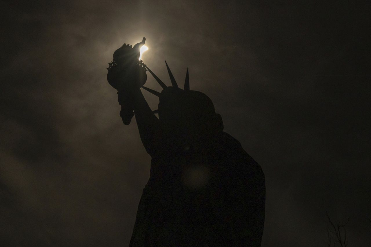 The moon partially covers the sun behind the Statue of Liberty during the a solar eclipse on the Liberty Island, Monday, April 8, 2024, in New York.