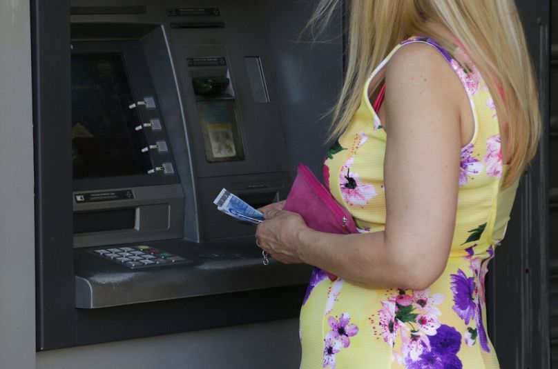 A woman uses an ATM of a bank in Athens, July 2015