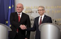 Dimitar Glavcsev (balra), az átmeneti kormány miniszterelnöke kezet fog a leköszönő kormányfővel, Nyikolaj Denkovval (jobbra)