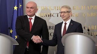 Dimitar Glavcsev (balra), az átmeneti kormány miniszterelnöke kezet fog a leköszönő kormányfővel, Nyikolaj Denkovval (jobbra)