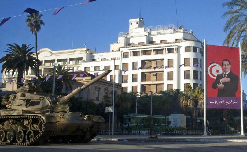 A tank is seen next to the portrait of former Tunisian President Zine El Abidine Ben Ali, on a street in Tunis, January 2011