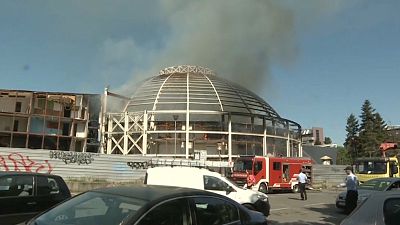 Bomberos intentan apagar el incendio en el Salón Universal de Skopie, Macedonia del Norte.