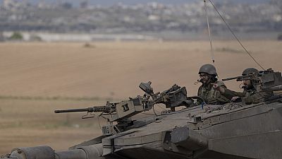Israeli soldiers move on the top of a tank near the Israeli-Gaza border, as seen from southern Israel, Tuesday, April 9, 2024.