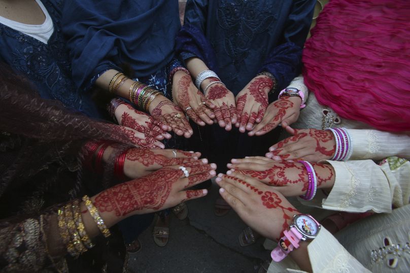Muslim girls display their hands painted with henna in traditional patterns to celebrate Eid al-Fitr in Peshawar, Pakistan, Wednesday, April 10, 2024.