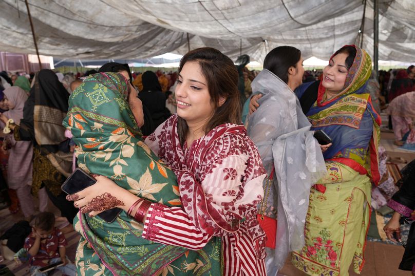 Muslim women share Eid greeting after performing an Eid al-Fitr prayer at historical Badshahi mosque in Lahore, Pakistan, Wednesday, April, 10, 2024.