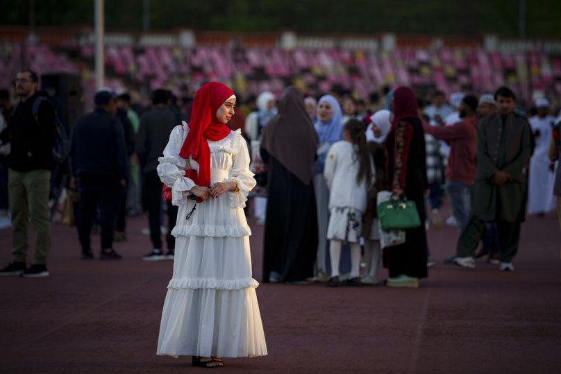 A young woman poses for a friend before the Eid al-Fitr prayers in Bucharest, Romania, Wednesday, April 10, 2024.