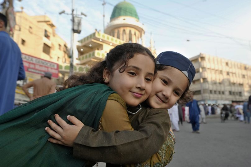 Muslim children share Eid greeting after attending an Eid al-Fitr prayer in Karachi, Pakistan, Wednesday, April, 10, 2024.