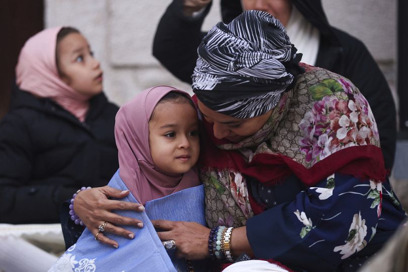 Bosnian Muslim woman hugs her daughter prior to the start of the prayer during the first day of Eid al-Fitr in Sarajevo, Bosnia, Wednesday, April 10, 2024.
