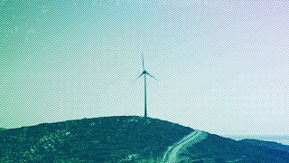 A road leads past a wind turbine stands on the Aegean island of Tilos, August 2018