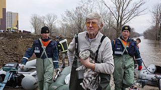 Muškarac drži svoju mačku dok vuče čamac s radnicima hitne pomoći u poplavljenom području u Orenburgu, Rusija, srijeda, 10. travnja 2024. 