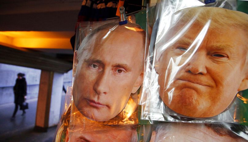 Face masks depicting Russian President Vladimir Putin and US President-elect Donald Trump hang for sale at a souvenir street shop in St Petersburg, December 2016