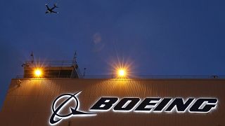 A plane flies over a sign on Boeing's 737 delivery centre at Boeing Field in Seattle, Oct. 19, 2015.