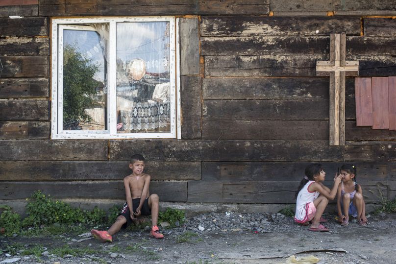 Children rest in the shade of a church wall inside a Roma neighbourhood on the outskirts of Uzhgorod, June 2018