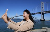 Content creator Cynthia Huang Wang works below the San Francisco-Oakland Bay Bridge in San Francisco, Monday, April 8, 2024.