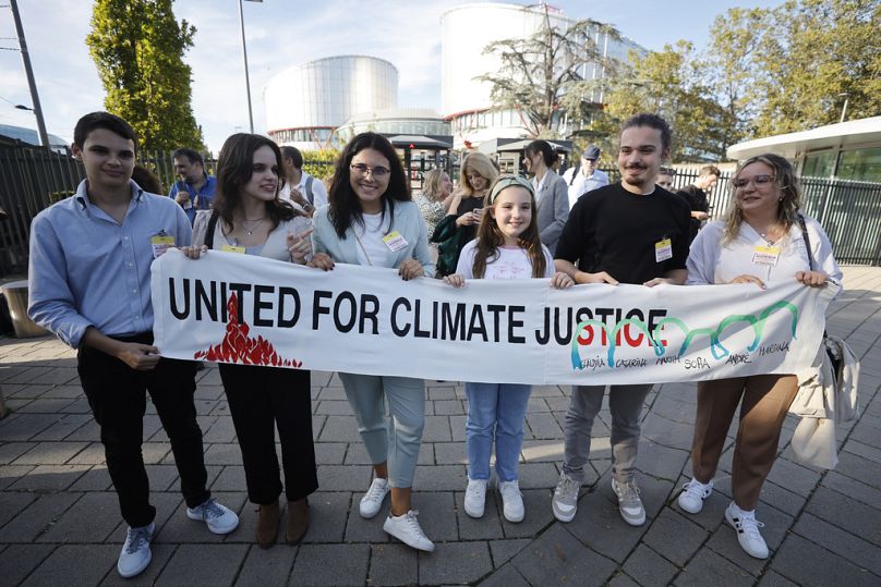 Mariana, centre right, Claudia Agostinho, right, Martim Agostinho, second right, Sofia Oliveira, second left, her brother Andre, left, with Catarine Mota, pose with a banner.