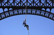 Anouk Garnier climbs up second floor of the Eiffel Tower by rope. 