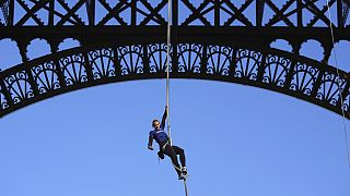 Anouk Garnier climbs up second floor of the Eiffel Tower by rope. 