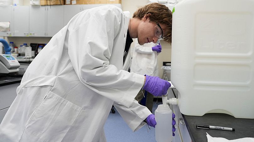 Logan Feeney pours a PFAS water sample into a container for research, 10 April 2024, at a US Environmental Protection Agency lab in Cincinnati.