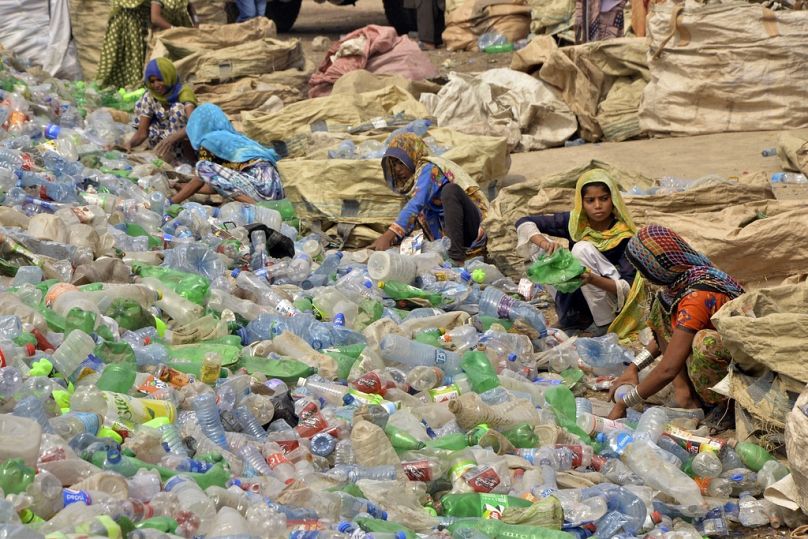 Pakistani laborers, mostly women, sort through empty bottles at a plastic recycling factory in Hyderabad, May 2023