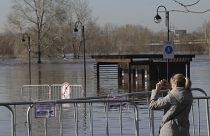 A woman takes a photo of a flooded area next to Ural river in Orenburg, Russia.