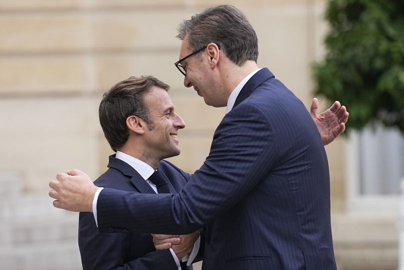 French President Emmanuel Macron, left, welcomes Serbian President Aleksandar Vucic