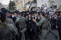 Israeli border police officers push back Ultra-Orthodox Jewish men during a protest against army recruitment in Jerusalem