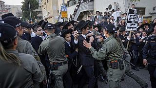 Israeli border police officers push back Ultra-Orthodox Jewish men during a protest against army recruitment in Jerusalem