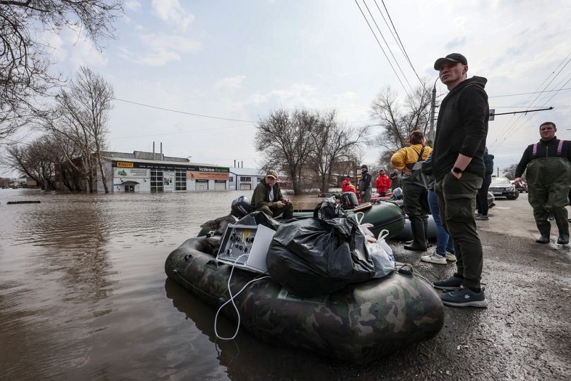 Anwohner der Stadt Orenburg stehen konnten einen Teil ihrer Habseligkeiten mit Booten retten.