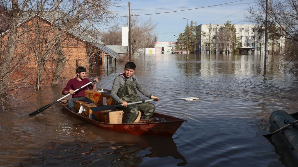 Csónakkal viszi az élelmiszert két férfi az oroszországi Orenburgban 2024. április 11-én