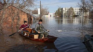 Csónakkal viszi az élelmiszert két férfi az oroszországi Orenburgban 2024. április 11-én