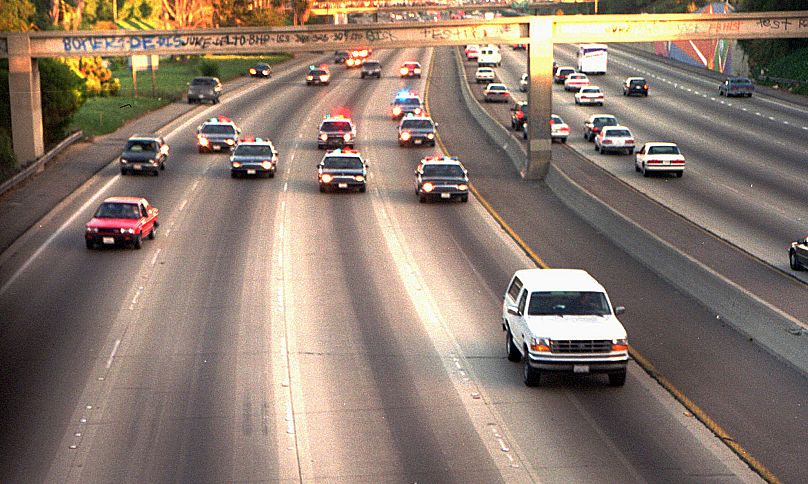A white Ford Bronco, driven by Al Cowlings carrying O.J. Simpson, is trailed by Los Angeles police cars as it travels on a freeway in Los Angeles, 17 June 1994