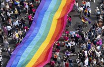People hold a rainbow flag as they attend the 45th Berlin Pride Parade for Christopher Street Day (CSD) in Berlin, Germany.