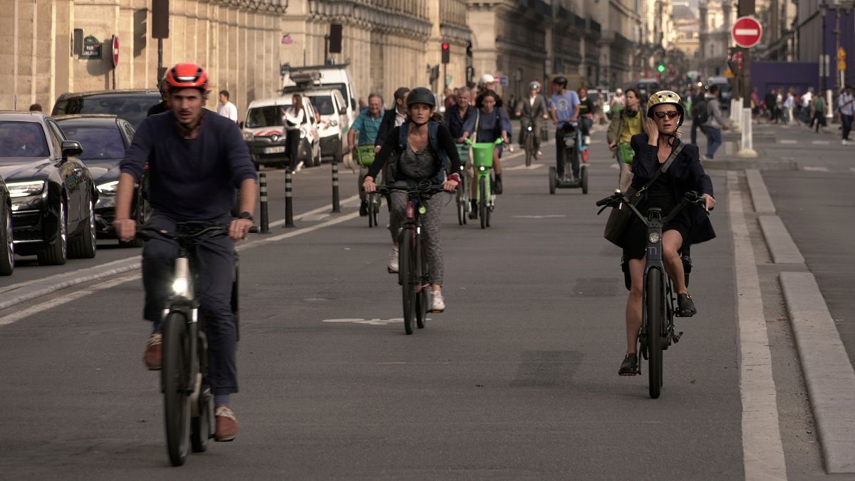 İnsanlar Paris'teki Rivoli Caddesi'nde bisiklet sürüyor.