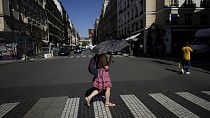 A woman holds an umbrella to protect herself from the sun during a heat wave in Paris, 6 September, 2023.