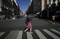 A woman holds an umbrella to protect herself from the sun during a heat wave in Paris, 6 September, 2023.