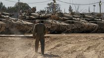 Israeli soldiers work on tanks at a staging ground near the border with the Gaza Strip, in southern Israel, Thursday, April 11, 2024.
