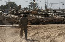 Israeli soldiers work on tanks at a staging ground near the border with the Gaza Strip, in southern Israel, Thursday, April 11, 2024.