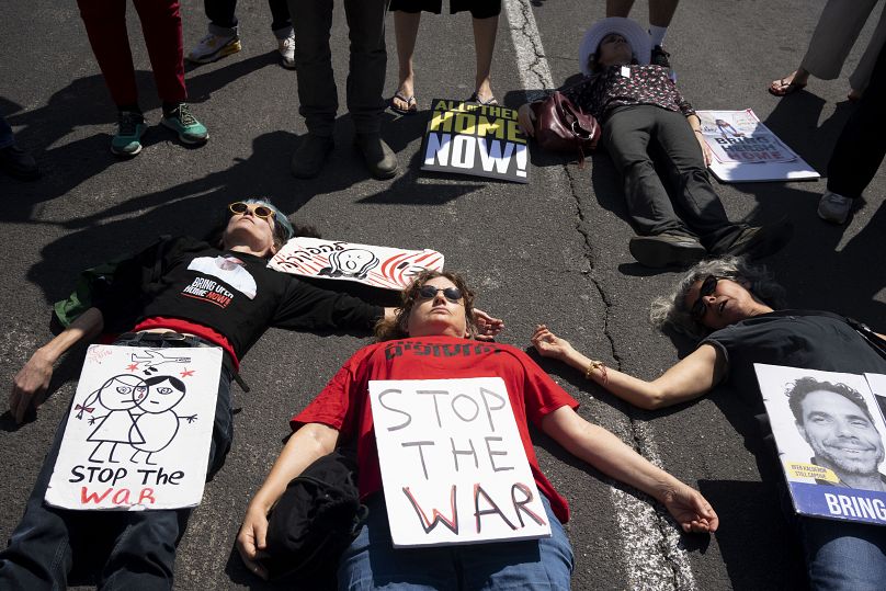 Relatives of hostages held in Gaza and their supporters lie in the road to block traffic outside of the U.S. Embassy Branch Office in Tel Aviv, Israel, Friday, April 12, 2024