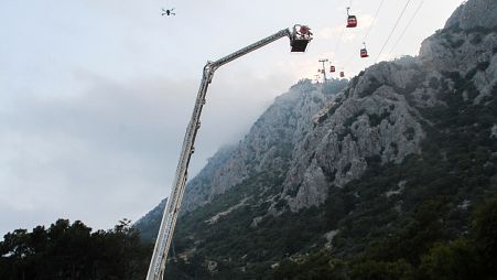A rescue team work with passengers of a cable car transportation systems outside Antalya, southern Turkey, April, Friday 12, 2024. 