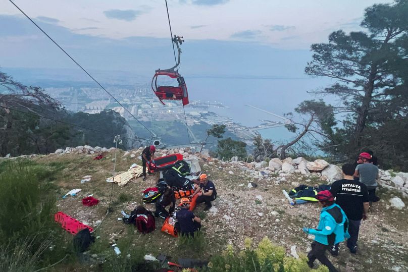 Rescue and emergency team members work with passengers of a cable car transportation system outside Antalya, southern Turkey, Friday, April 12, 2024.