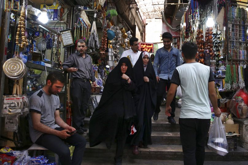 ARQUIVO - Nesta fotografia de arquivo de 19 de julho de 2016, iranianos caminham pelo bazar Tajrish, no norte de Teerão, Irão.