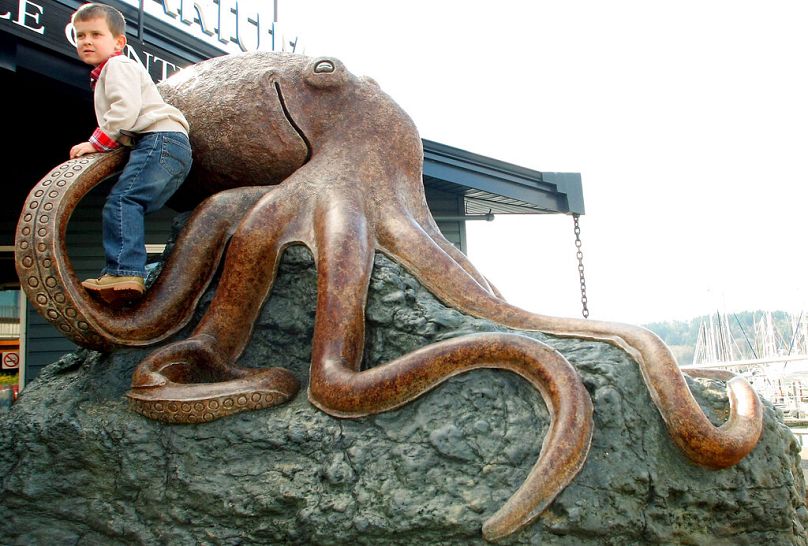 A boy climbs the new octopus statue in front of the Poulsbo, Wash. Marine Science Center, March 2013