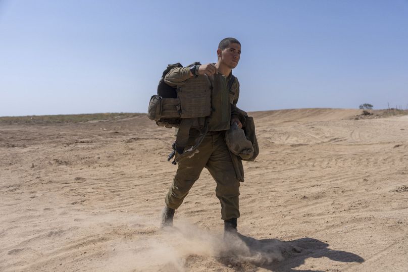 An Israeli soldier walks near the Israeli-Gaza border, April 2024
