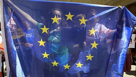 Protesters hold a EU flag as they gather outside the parliament building in Tbilisi, Georgia, April 16, 2024.