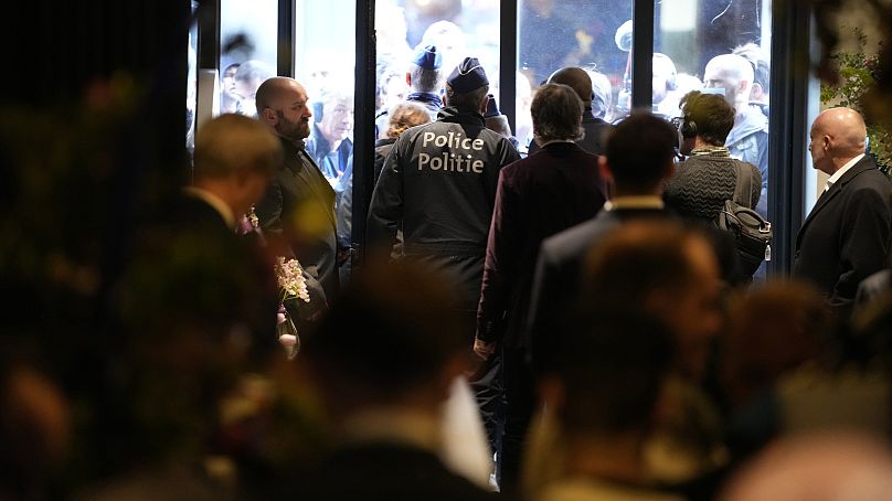 Police walk out the front entrance during the National Conservatism conference in Brussels, Tuesday, April 16, 2024.