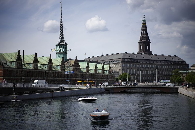 FILE - A boat wades through the Nyhavn river, with the Old Stock Exchange building left in the background, in Copenhagen, Denmark, Wednesday, June 29, 2022.