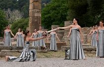 Actors light a torch at the official flame lighting for the Paris Olympics at the home of the ancient games in Greece.