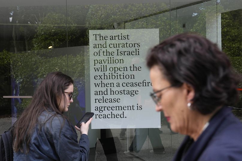 People stand in front of the closed Israeli national pavilion at the Biennale contemporary art fair in Venice, Italy, Tuesday, April 16, 2024