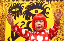 Japanese artist Yayoi Kusama poses for photographers at the 'Earth Carrying with it a Tale of the Cosmos' at the Tate Modern in London, 2012. 